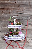 Easter flower arrangement on cake stand on red garden chair