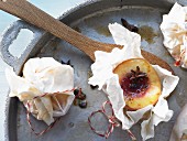 Peaches in parchment paper with star anise and honey