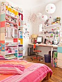 Sewing and craft utensils on open-fronted shelves next to desk in bedroom