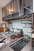 Living space in industrial loft apartment with spiral staircase leading to mezzanine
