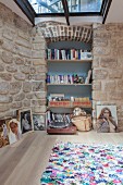 Bookshelves with blue back wall in niche in stone wall