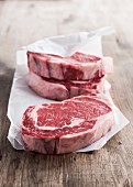 Raw rib eye steaks on butcher paper