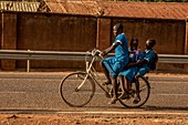Schoolchildren riding a bicyle
