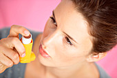 Woman using aerosol inhaler