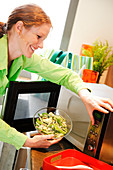 Woman using microwave oven