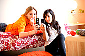 Two teenage girls reading SMS