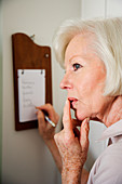Elderly woman using a note board