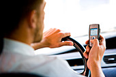 Man driving while using phone