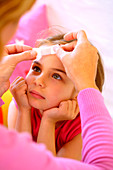 Woman applying band-aid on a girl