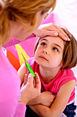 Woman checking temperature of kid