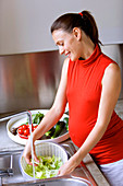 Pregnant woman washing vegetables