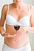 Pregnant woman drinking a glass of wine