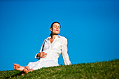 Pregnant woman sitting on grass