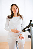 Pregnant woman with exercise bicycle