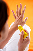 Woman applying cream on her hand