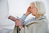 Doctor comforting elderly woman