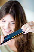 Woman using hair straightener