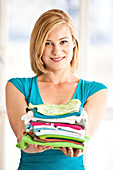 Woman holding a pile of clothes