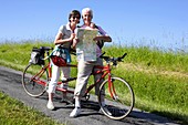 Senior couple riding tandem bicycle