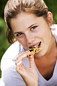Teenage girl eating cereal bar