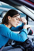 Tired woman in her car