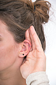 Woman with hand cupped to ear