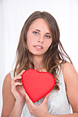 Young woman holding red heart shape