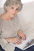 Woman using laptop looking at camera