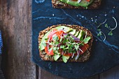 A Gluten-Free Vegan Nut and Seed Bread with avocado salad topping