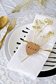 Heart-shaped tag and dried flower sprayed gold on napkin