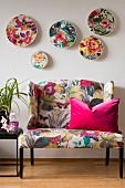 Floral fabrics in embroidery hoops mounted on wall above sofa with floral print upholstery