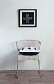 Picture with cross motif above chair with cross pattern on scatter cushion