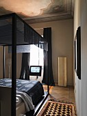 Schlafzimmer mit alter Deckenmalerei und modernem Himmelbett