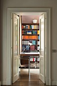 Bookcase in study seen through open double doors