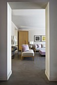 View into elegant lounge with pastel cushions and ottoman