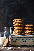 Stacks of Anzac biscuits on a biscuit tin