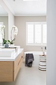 Free-standing bathtub in beige and white bathroom