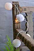 Hand-made fairy lights with white baubles and wool pompoms