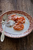 Roasted apricots with vanilla, coconut sugar, cinnamon and coconut cream on a plate