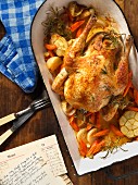 Chicken with garlic and vegetables in a roasting pan
