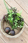 Fresh figs and herbs in a wooden bowl