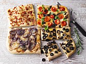 Four variations of focaccia with onion, olives, bacon and cherry tomatoes