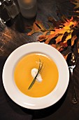 Ginger Yam Bisque in white bowl with autumn leaves