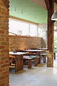 Modern wooden tables, rustic brick walls and wooden beams
