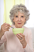 Woman eating from a bowl with a spoon