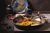 Spices turmeric and dry red hot chili peppers on metal plate