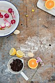 Blockschokolade, Zitrone, Orange, Eier und Wasserschale mit schwimmenden Blüten auf Vintage Untergrund