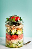 Zutaten für Quinoa-Gemüse-Salat in Einmachglas geschichtet