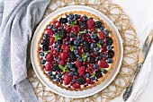 A summer berry tart on a white board