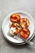 Plate with grilled peach with greek yogurt, honey and decorated with fresh thyme